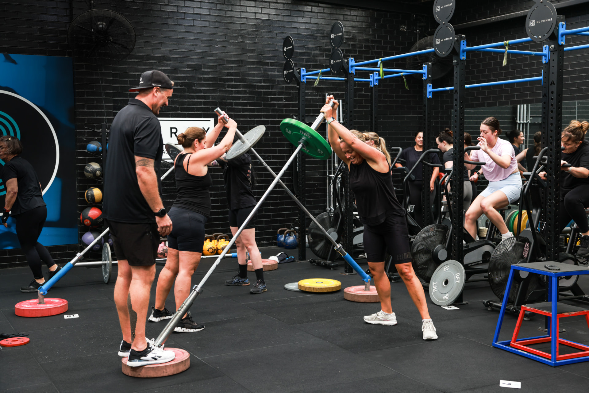 A coach guiding members through a barbell session at BFT Abbotsford